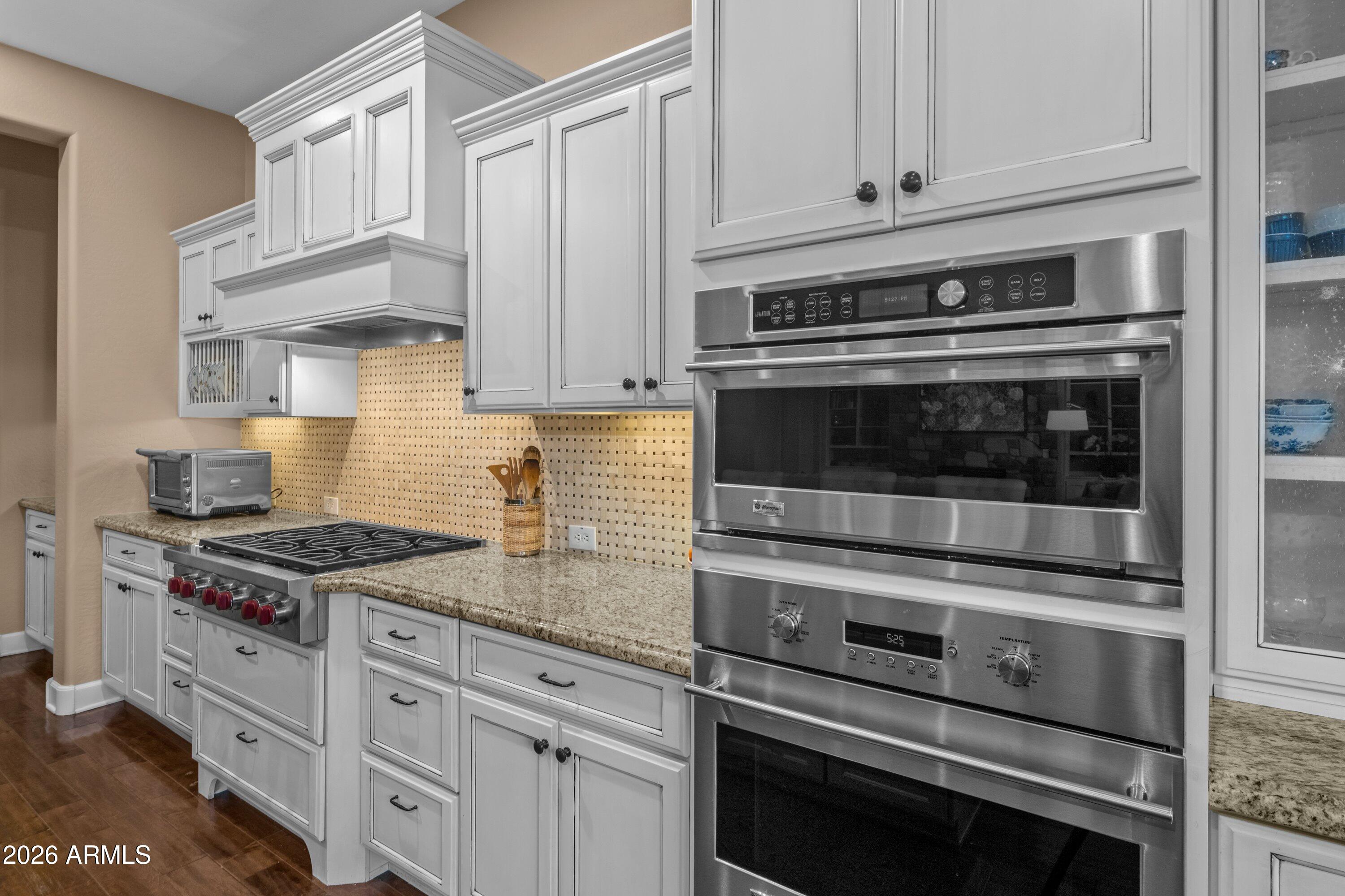 3738 East Riopelle Avenue Gilbert, AZ 85298 - Photo 20 of 97 a kitchen with granite countertop a stove microwave and cabinets