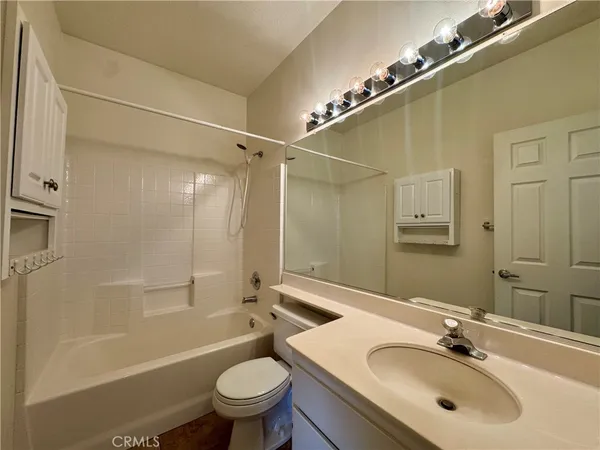 a bathroom with a sink mirror toilet and bathtub