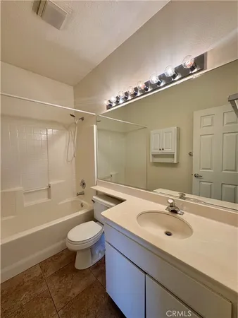 a bathroom with a sink a toilet a mirror and shower