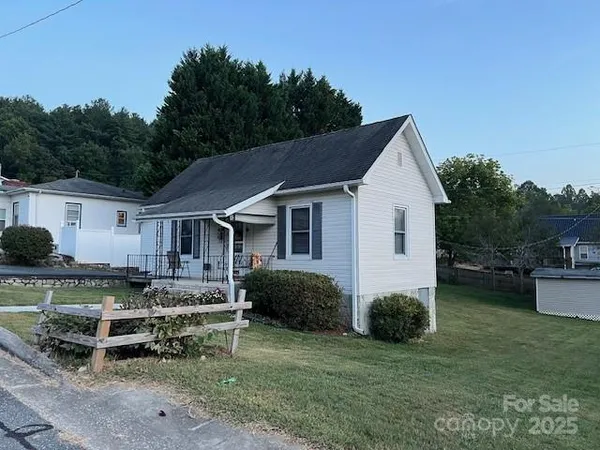 a view of a house with a yard and sitting area