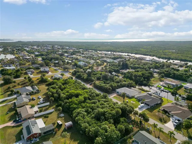 an aerial view of residential houses with outdoor space and trees