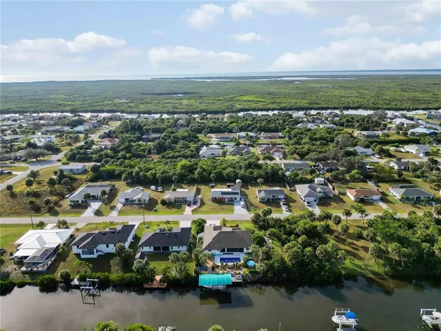 an aerial view of a city with lots of residential buildings ocean and mountain view in back