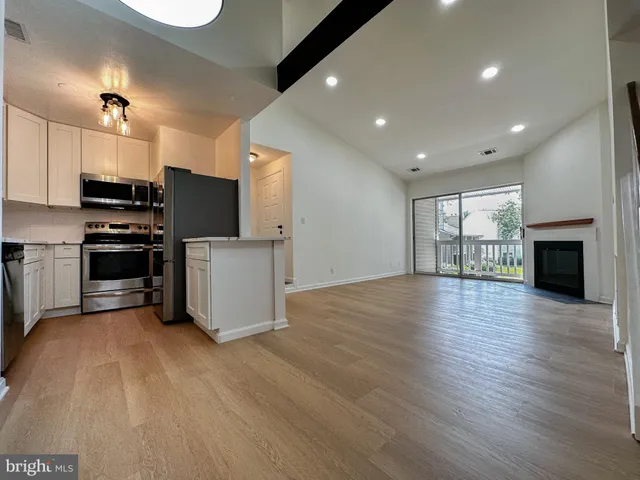 a view of a kitchen with a sink stove cabinets and empty room