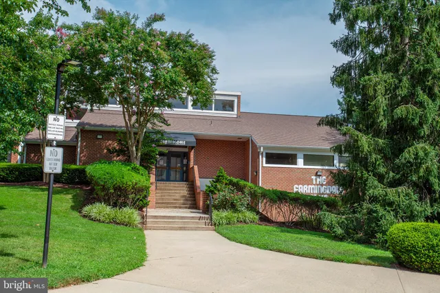 a front view of a house with a yard and potted plants