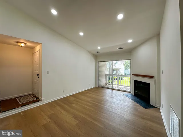 an empty room with wooden floor and a fireplace