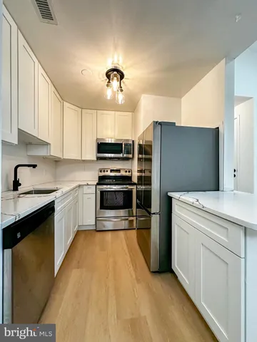a kitchen with stainless steel appliances kitchen island granite countertop a refrigerator and a stove top oven