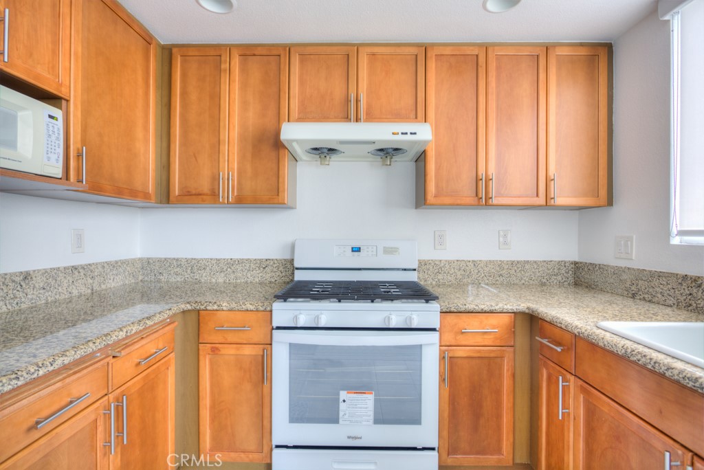 580 West Main Street, Unit 302 Alhambra, CA 91801 - Photo 18 of 41 a kitchen with granite countertop cabinets sink and a stove