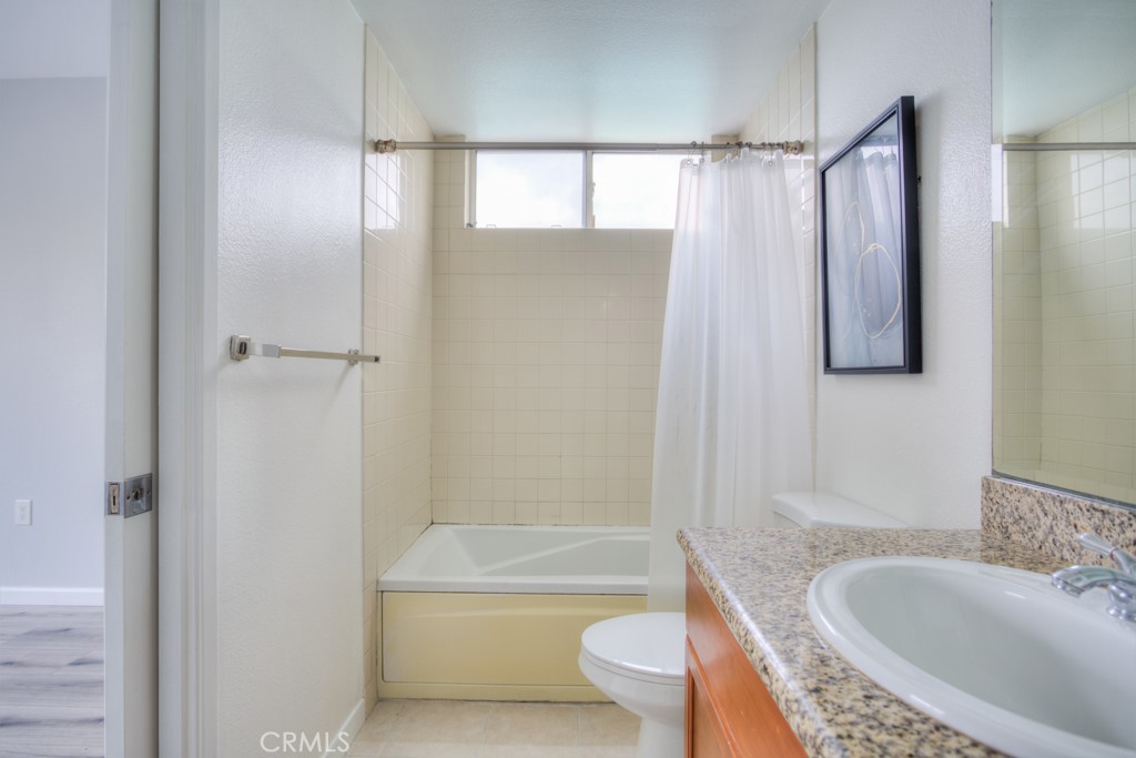 580 West Main Street, Unit 302 Alhambra, CA 91801 - Photo 24 of 41 a bathroom with a granite countertop toilet a sink and bathtub