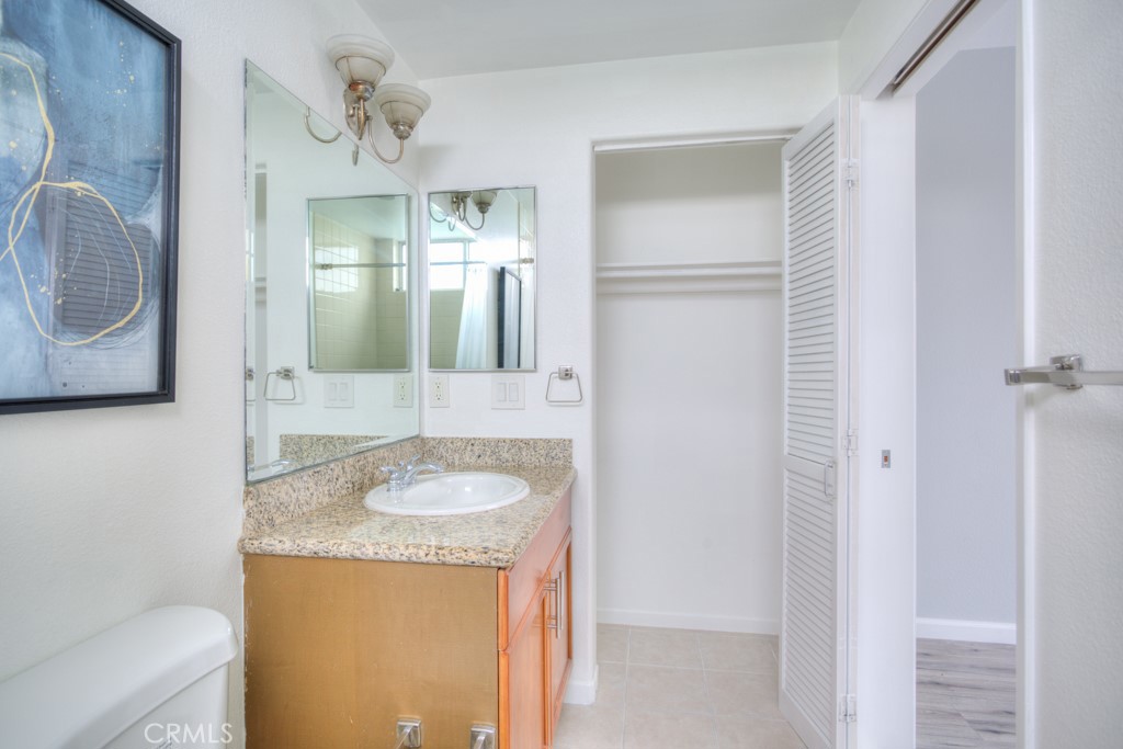 580 West Main Street, Unit 302 Alhambra, CA 91801 - Photo 25 of 41 a bathroom with a granite countertop sink and a mirror