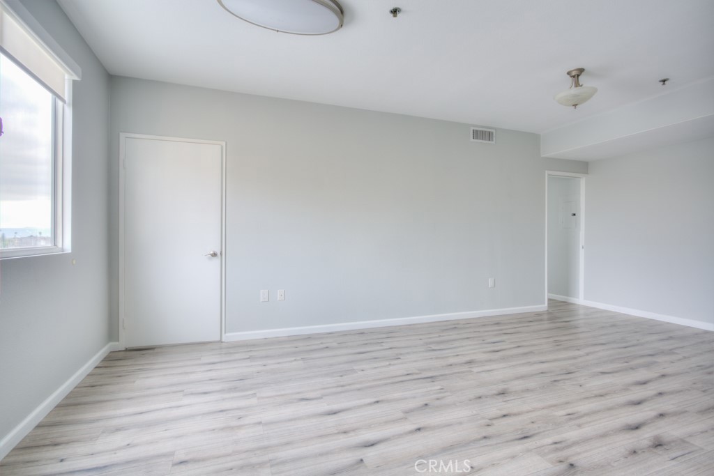 580 West Main Street, Unit 302 Alhambra, CA 91801 - Photo 9 of 41 a view of an empty room with wooden floor and a window