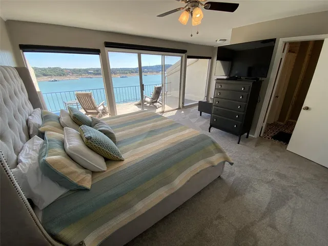 a bedroom with a bed and large windows