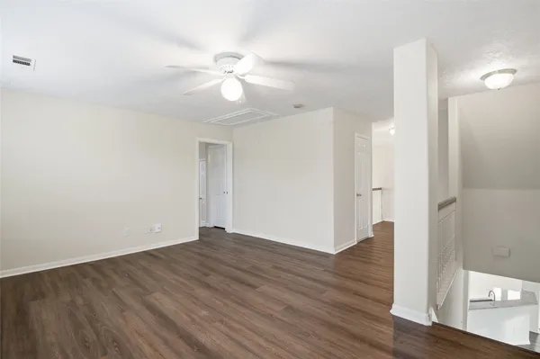 a view of an empty room with wooden floor
