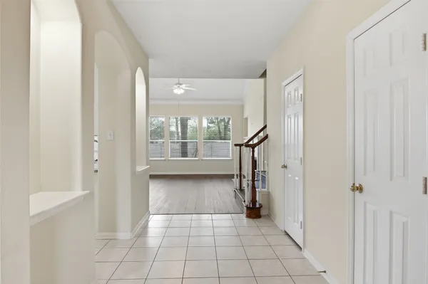 a view of a hallway with wooden floor and a living room