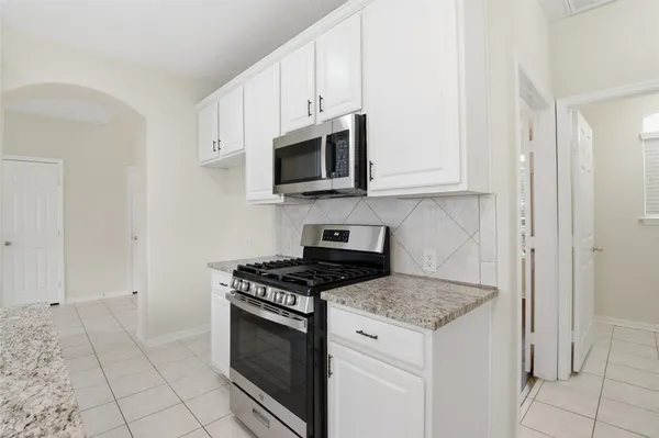 a kitchen with granite countertop white cabinets stainless steel appliances and sink