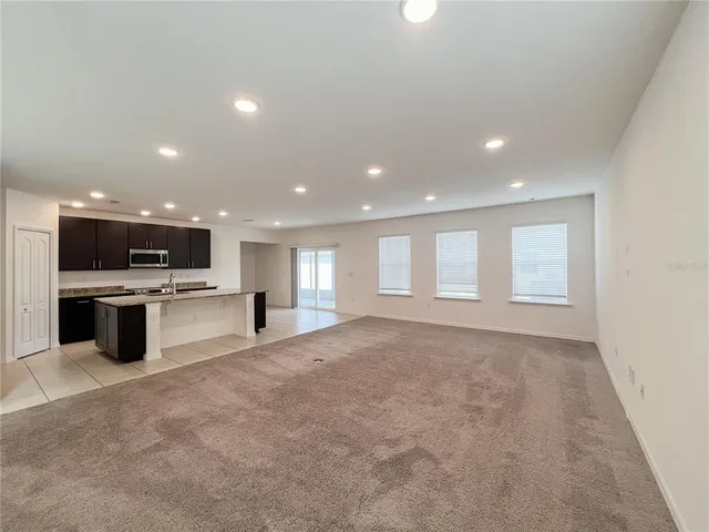 a view of an empty room with a kitchen