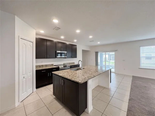 a kitchen with stainless steel appliances granite countertop a stove a sink and a refrigerator
