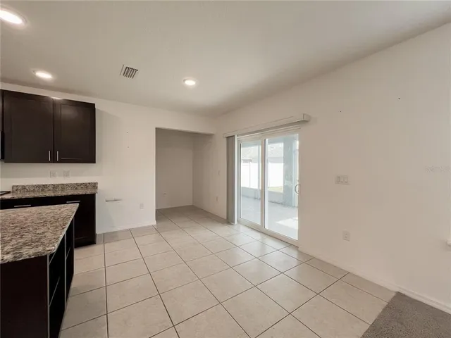 a view of an empty room with a kitchen