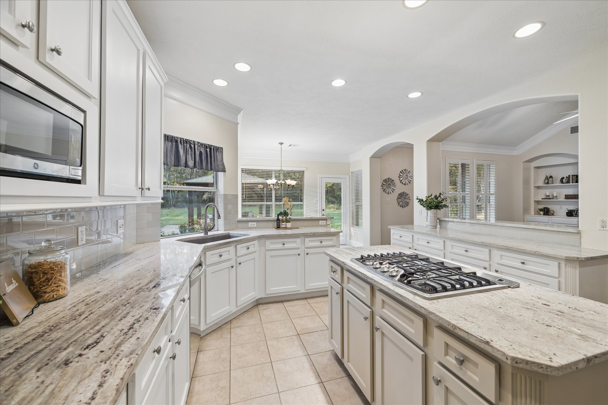 14530 Millhouse Road Pinehurst, TX 77362 - Photo 14 of 46 Additional kitchen view with granite countertops, tile backsplash and open sightlines to the living and breakfast room areas.