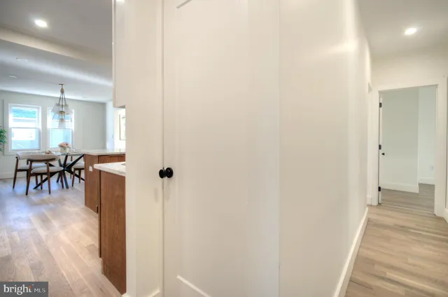 a view of a hallway with dining room and wooden floor