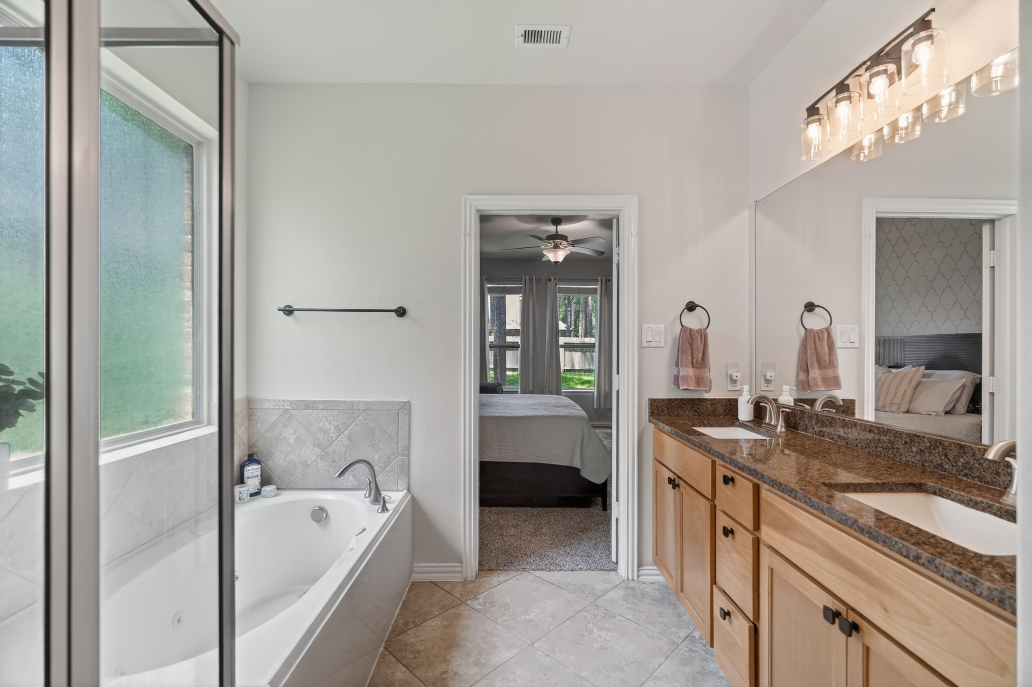 79 West Jagged Ridge Circle Spring, TX 77389 - Photo 26 of 50 A relaxing soaking tub anchors this corner of the primary bathroom, framed by a large window and positioned just steps from the dual vanity. It's the perfect spot to unwind after a long day, right in the comfort of your own home.