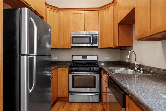 a kitchen with granite countertop a sink stove and refrigerator