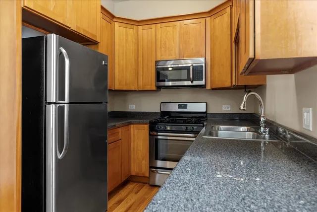 a kitchen with stainless steel appliances granite countertop a refrigerator stove and microwave