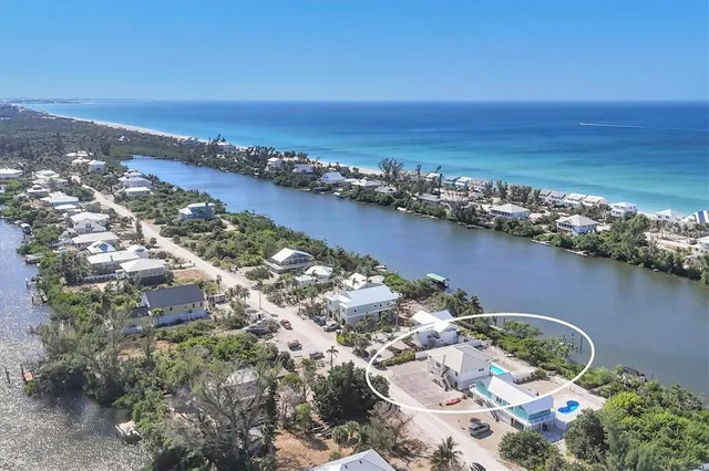 an aerial view of ocean and residential houses with outdoor space