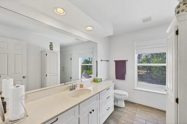 a spacious bathroom with a double vanity sink toilet mirror and bathtub