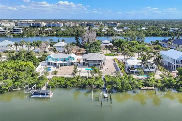 an aerial view of residential houses with outdoor space and lake view