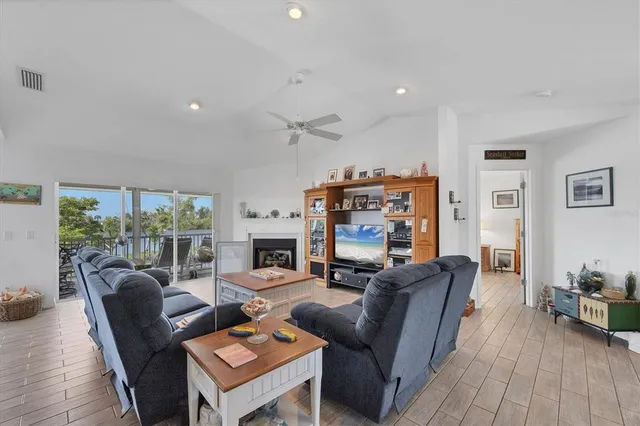 a living room with furniture a fireplace and a floor to ceiling window