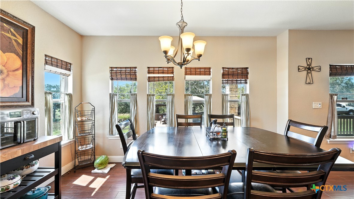 121 Carrizo Ridge Floresville, TX 78114 - Photo 19 of 43 a view of a dining room with furniture large windows and wooden floor