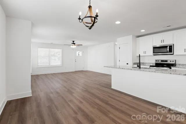 a view of kitchen with granite countertop cabinets and wooden floor