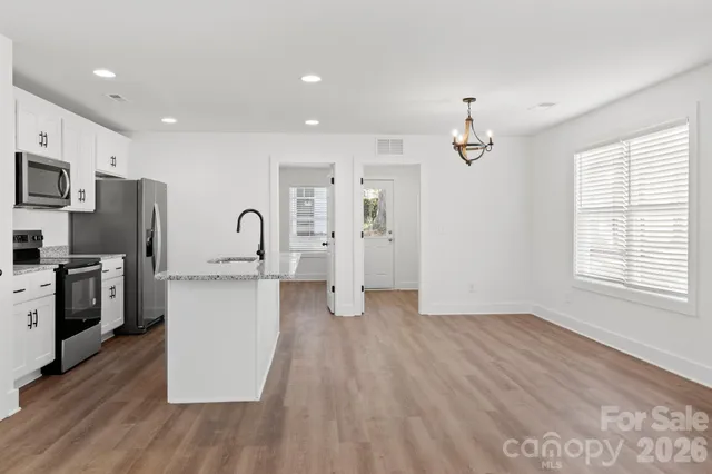 a view of a kitchen with a sink a refrigerator and window