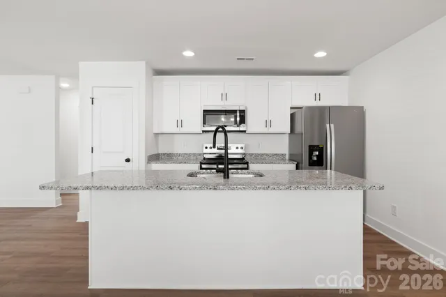a kitchen with stainless steel appliances granite countertop a sink a refrigerator and a granite counter tops