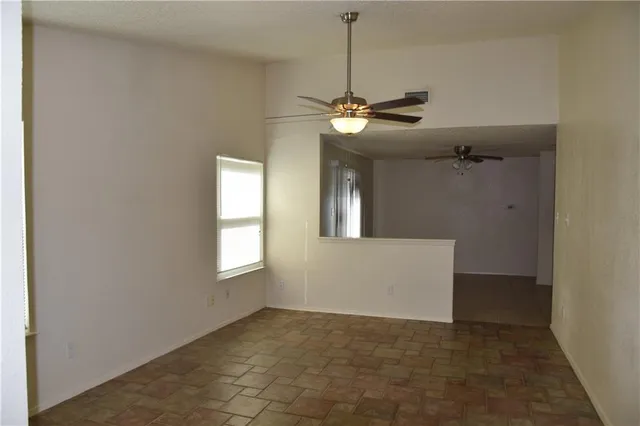 a view of a room with a ceiling fan and window