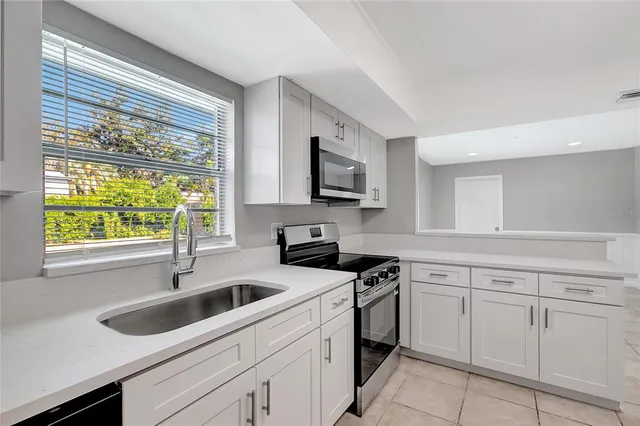 a kitchen with a sink stove top oven and cabinets