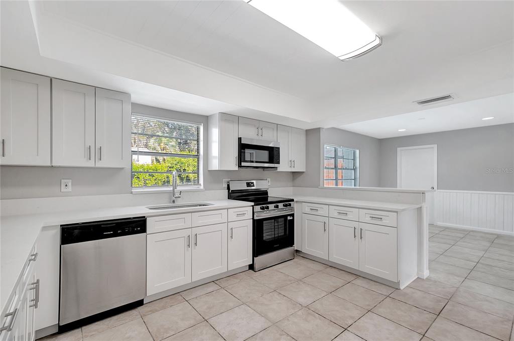 114 Barkfield Street Brandon, FL 33511 - Photo 20 of 59 a kitchen with white cabinets appliances and a window