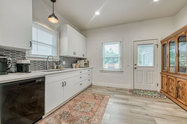 a kitchen with granite countertop a stove a sink and a window