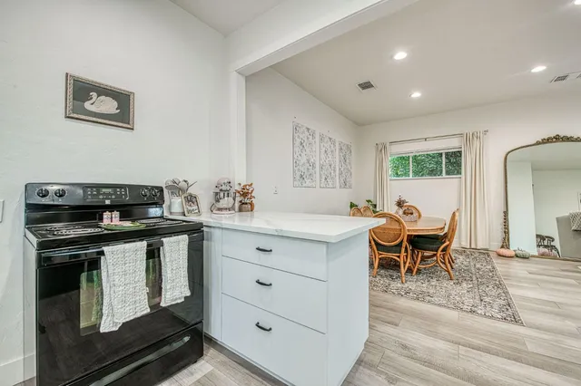 a kitchen with a stove and a dining table