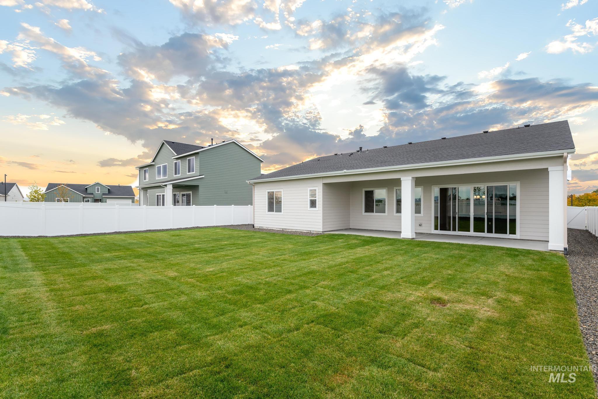 1220 Grassland Street Middleton, ID 83644 - Photo 9 of 11 Back of house at dusk with a fenced backyard and a patio
