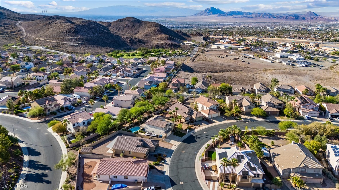 708 Vortex Avenue Henderson, NV 89002 - Photo 62 of 71 An aerial perspective reveals a vibrant neighborhood nestled against the mountains, offering sweeping desert and city views.