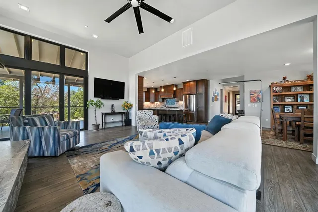 a kitchen with stainless steel appliances granite countertop a table chairs sink and wooden floor