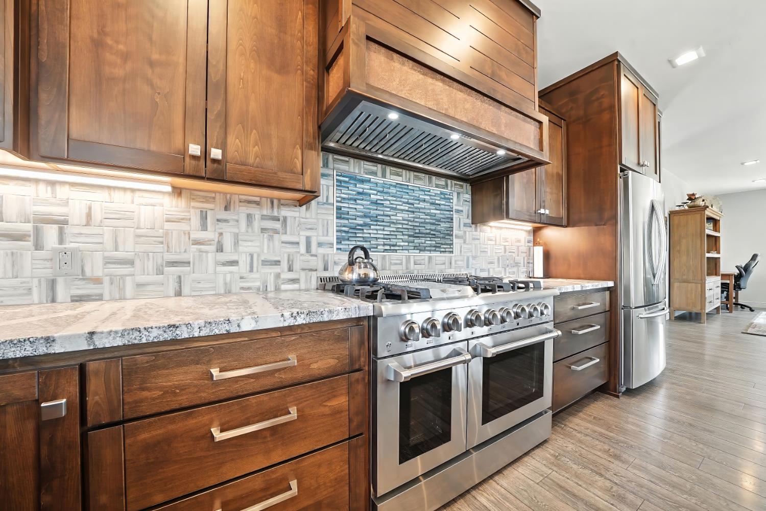 7401 Schaad Road Wilseyville, CA 95257 - Photo 31 of 76 a kitchen with granite countertop stainless steel appliances and wooden cabinets