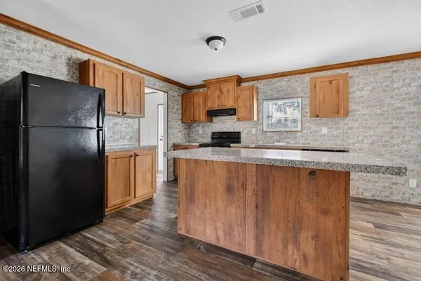 a kitchen with stainless steel appliances granite countertop a sink and a refrigerator