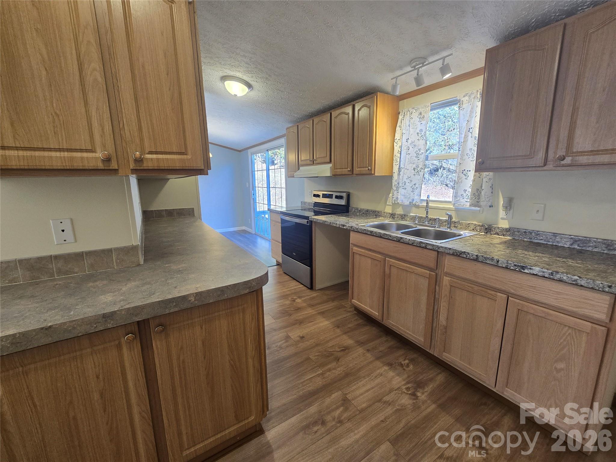 71 London Lane Clyde, NC 28721 - Photo 11 of 33 a kitchen with stainless steel appliances granite countertop wooden cabinets a stove top oven a sink and dishwasher with wooden floor