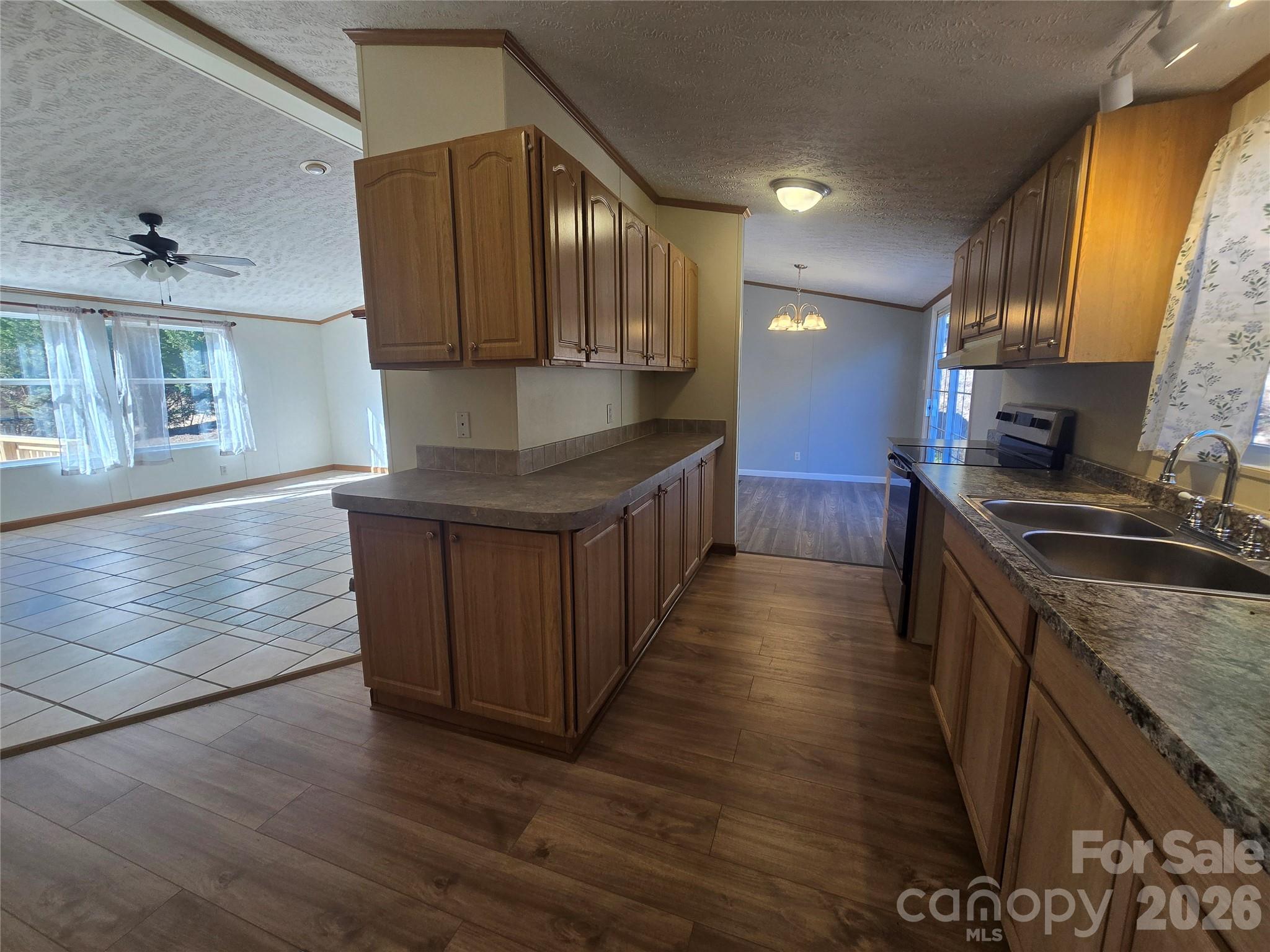 71 London Lane Clyde, NC 28721 - Photo 12 of 33 a kitchen with stainless steel appliances granite countertop a sink a stove and a wooden floors