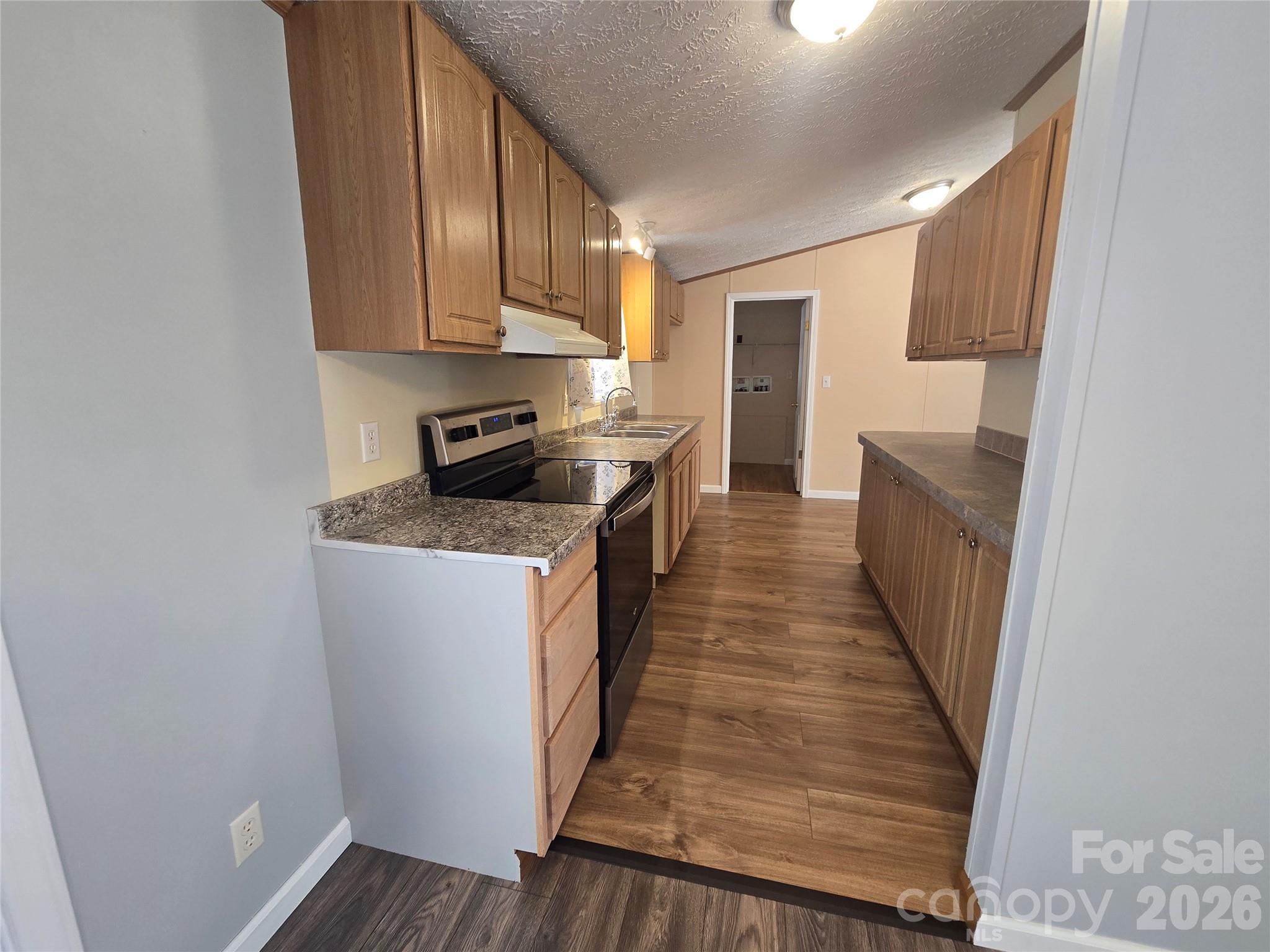 71 London Lane Clyde, NC 28721 - Photo 13 of 33 a kitchen with granite countertop white cabinets and stainless steel appliances