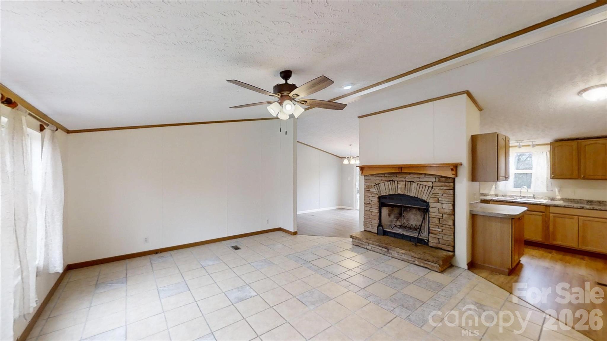 71 London Lane Clyde, NC 28721 - Photo 15 of 33 a view of an empty room with a fireplace and a chandelier fan
