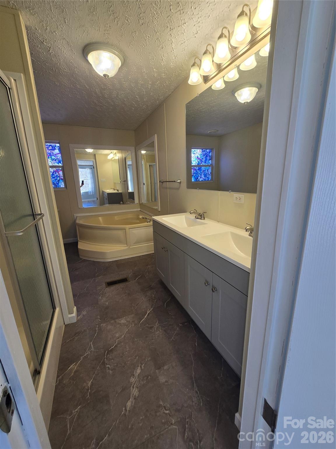 71 London Lane Clyde, NC 28721 - Photo 22 of 33 a bathroom with a sink a tub and a mirror