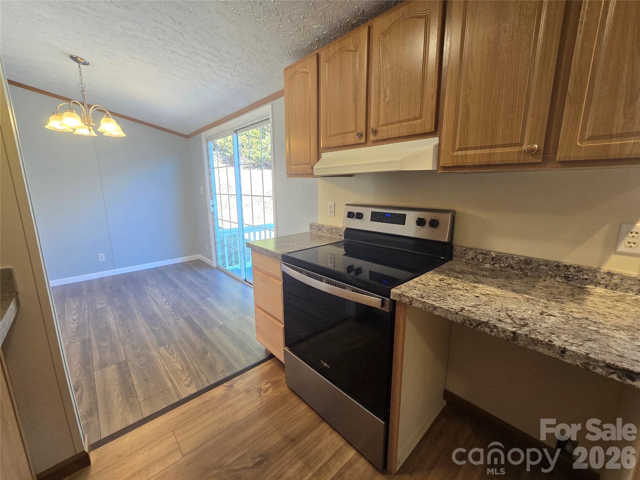 71 London Lane Clyde, NC 28721 - Photo 10 of 33 a kitchen with granite countertop wooden cabinets and a stove